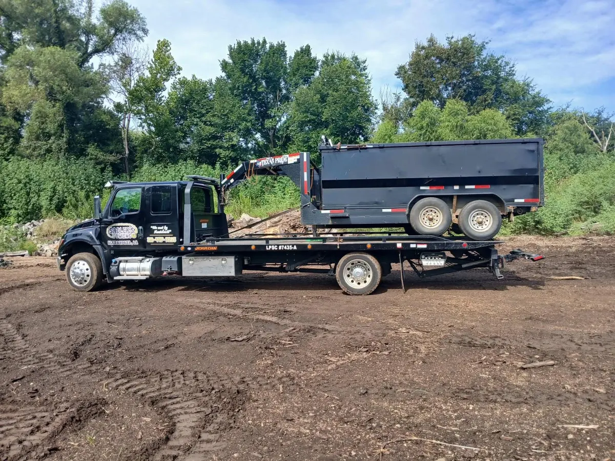 Gooseneck dump trailer hauled on a Sadler's Towing rollback